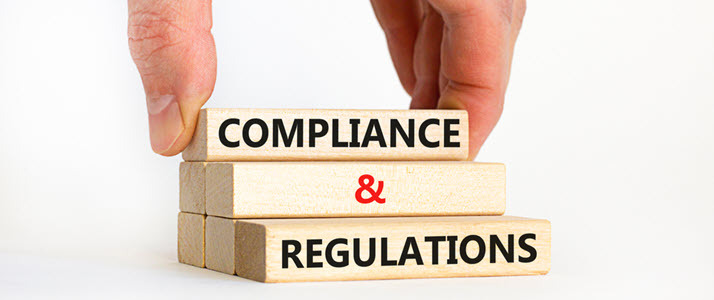 photo of fingers placing blocks that read compliance regulations photo of fingers placing blocks that read compliance regulations