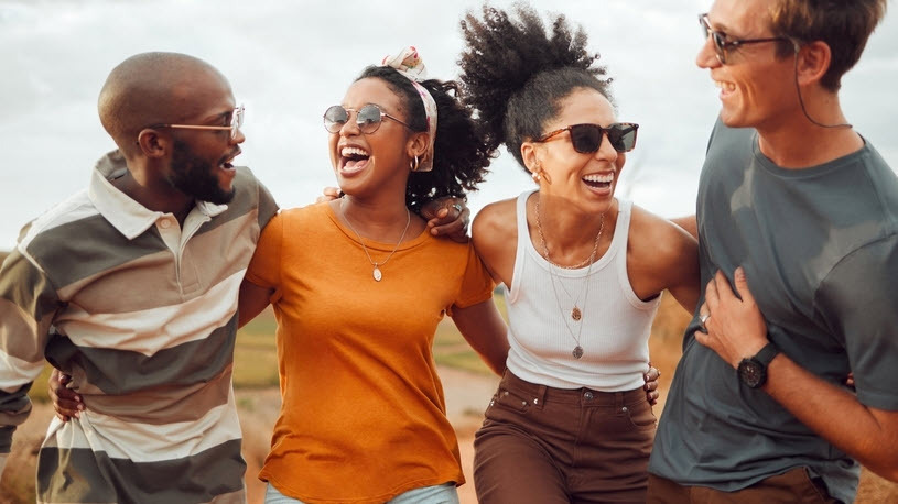 A group of workers embracing each other and laughing A group of workers embracing each other and laughing