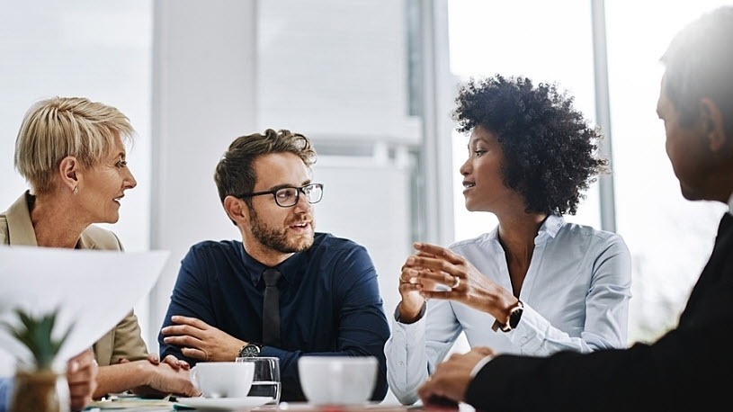 Black woman leading discussion with diverse peers in meeting Black woman leading discussion with diverse peers in meeting