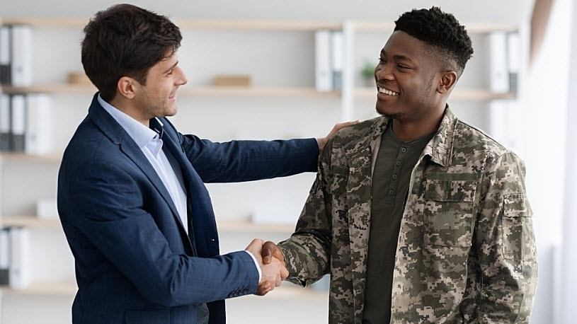 Vets Transitioning From the Military to Business A Veteran and businessperson shaking hands in office setting