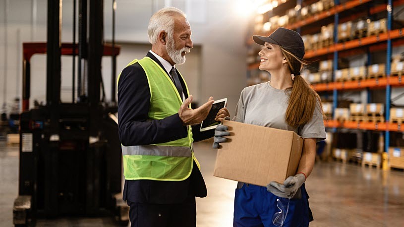 happy warehouse worker smiles talking to senior manager happy warehouse worker smiles talking to senior manager