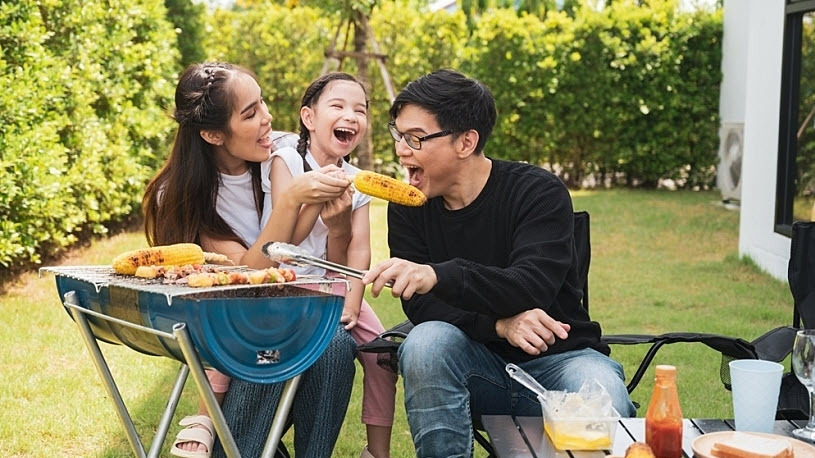 Family enjoying grilling in back yard on holiday