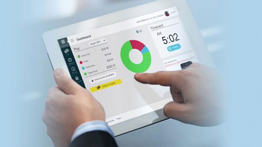 Man holding a tablet reviewing pay dashboard with timecard punch in