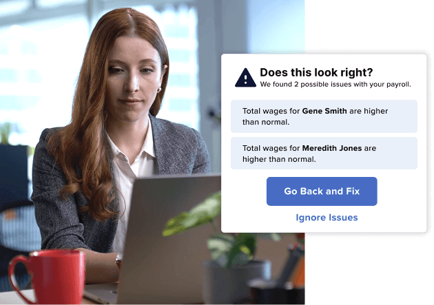 Woman working at a laptop sees a payroll alert about potential high wages for employees, with buttons to Go Back and Fix or Ignore Issues